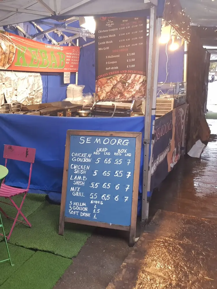 Semoorg stall with chalkboard price list and green and pink bistro chairs outside